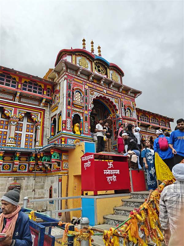 A brightly painted Himalayan temple with pilgrims at its steps