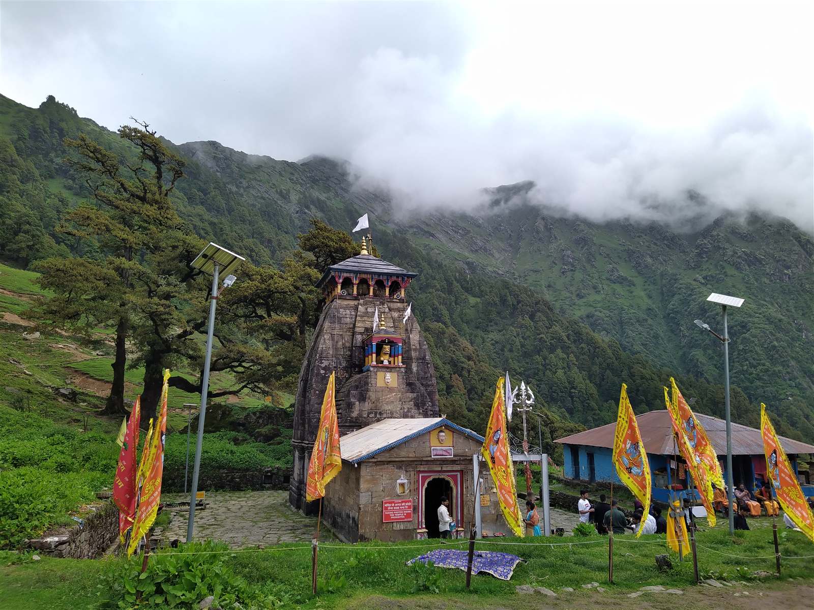 Stone temple beneath cloud-covered Himalayan slopes