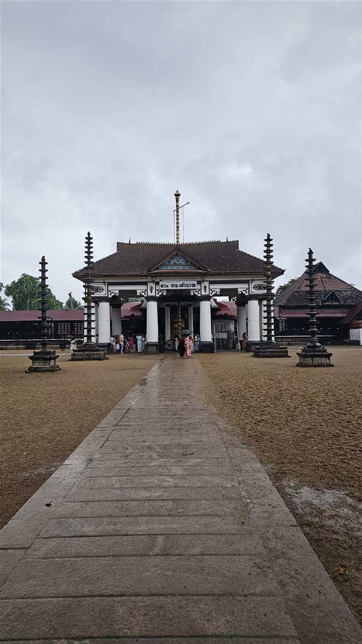 A traditional Kerala temple at the end of a wet stone path